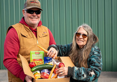 A couple holding a box full of food