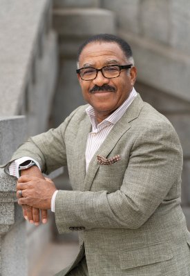 Penfield Tate III smiling leaning on a wall