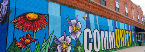 A painted exterior wall mural that says COMMUNITY
